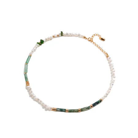 The necklace features alternating segments of smooth green crystals and delicate white pearls, accentuated with gold-tone metal details. It forms a continuous loop with a slight gold extension chain for adjustable length, creating an elegant and harmonious blend of natural colors and refined 