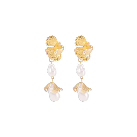  a pair of Aimee Leaf Gold Pendant Earrings. Each earring features a textured, gold leaf design at the top, mimicking the natural veining and shape of a leaf. Hanging from the leaf are two elements: a uniquely shaped baroque pearl and a small golden pendant shaped like a teardrop. The earrings combine organic motifs with elegant materials, creating a sophisticated accessory perfect for enhancing both casual and formal outfits. 
