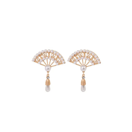 Each earring features an intricately designed fan-shaped top, encrusted with multiple small pearls arranged in a semi-circle that resembles a delicate lace pattern. Below this adorned fan, a single larger pearl dangles elegantly, complemented by a small golden teardrop charm that adds a sophisticated finish to the design. 