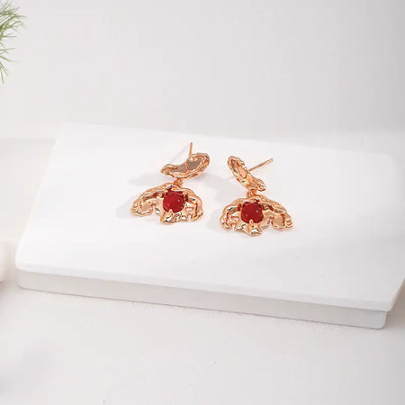 A close-up back view Aimee Red Agate Crystal Stud Earrings, showcasing the textured gold metalwork and secure fastening with the vivid red agate centerpiece.
