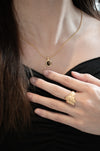 a model who are wearing a Anais & Aimee Tiger's Eye Pendant Necklace with a black outfit with wearing. a gold rings from anais & aimee 
