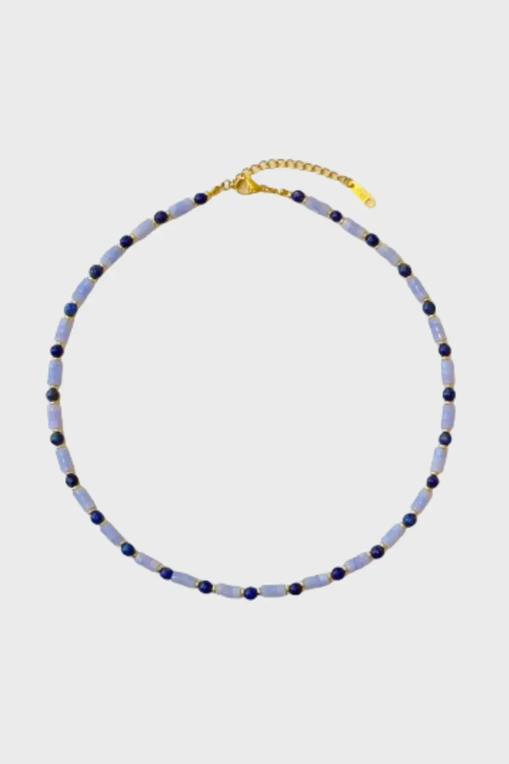 Close-up of the Ancient Sky Stone Celeste Necklace featuring alternating cylindrical and round blue gemstones, with 18K gold-plated clasp on a white background.