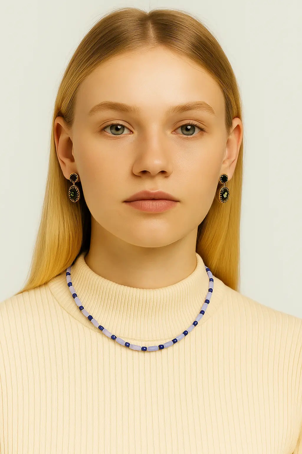 Blonde model wearing the Ancient Sky Stone Celeste Necklace styled with a cream ribbed top, showcasing the soft blue gemstone beading and delicate gold detail.

