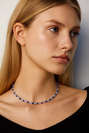 Side profile of model wearing the Ancient Sky Stone Celeste Necklace with soft natural makeup and black top, highlighting the elegance of the beaded gemstone design.

