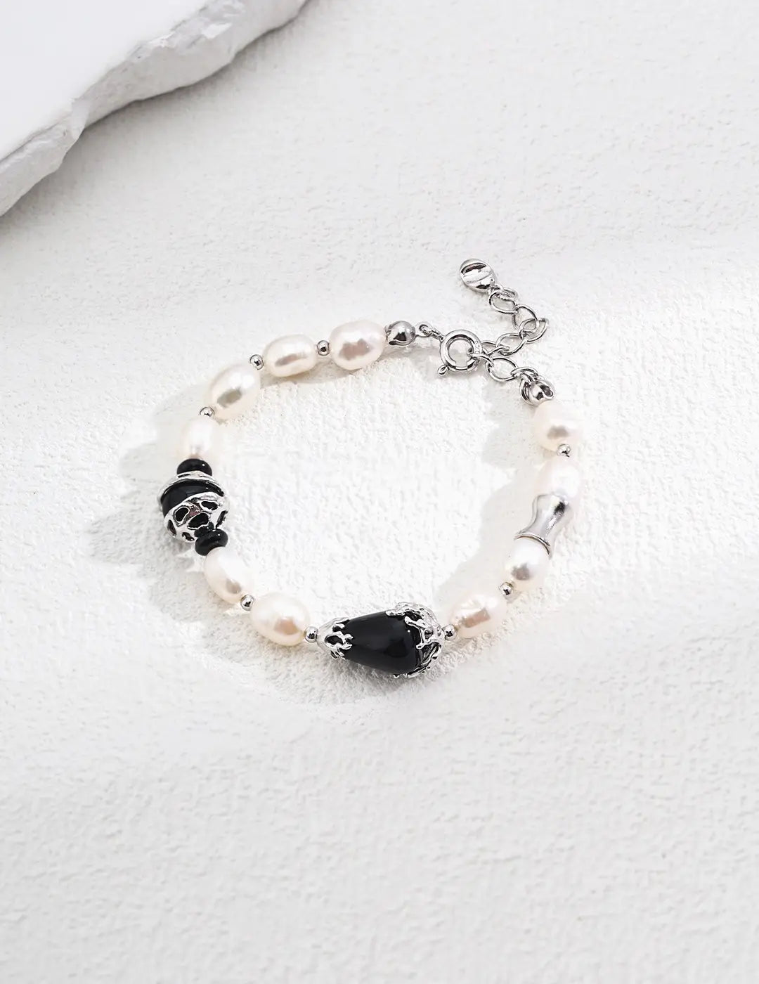 Close-up of the Black Obsidian Protection Bracelet Pearl by Anaïs & Aimee in silver. This version features polished pearls, black obsidian gemstones, and sleek silver details for a refined, modern aesthetic in the UK