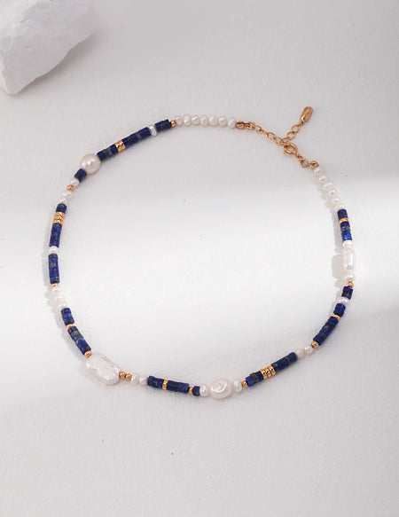 A single Navy Blue Lapis Lazuli Beads with Baroque Pearls Choker by Anaïs & Aimee, shown in full length to emphasize the adjustable gold chain and balanced design.