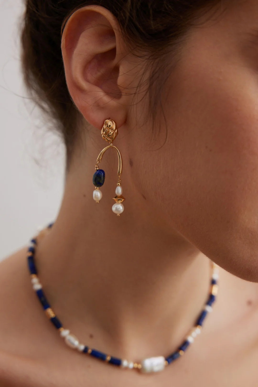Model side profile wearing Navy Blue Lapis Lazuli and Baroque Pearl choker with matching earrings