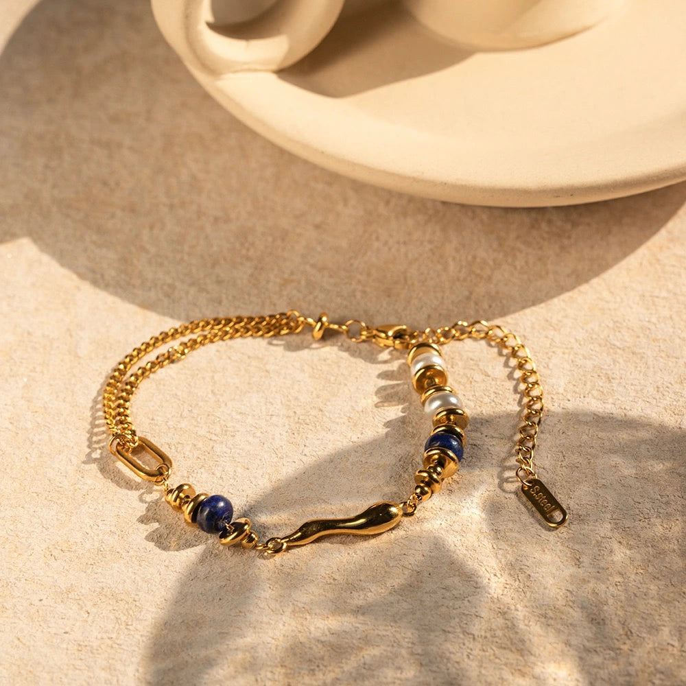 Gold chain bracelet stacked with a Bohemian luxe lapis lazuli stone bracelet, styled as lapis lazuli jewellery for women in the UK