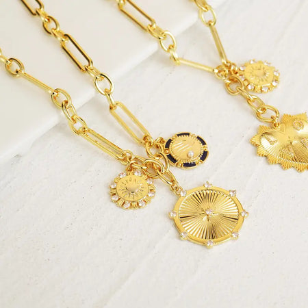 Celestial Harmony 3 Gold Charm Necklace featuring intricate sun, moon, and star charms on a gold chain, perfect for adding a celestial touch to any outfit.