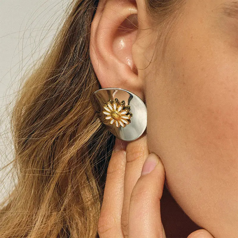 Close-up of modern floral silver earrings for women with gold accents, a chic accessory available in the UK as part of a silver earrings and necklace set.