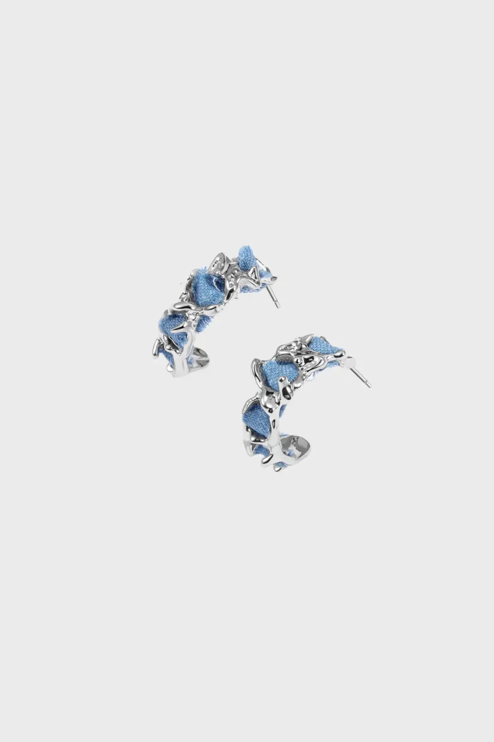 Contemporary denim-wrapped sterling silver hoop earrings with organic molten metal details, designed for modern elegance and statement style