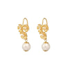  Elegant gold-tone floral earrings featuring intricate petal designs with small central pearls and a larger, smooth pearl drop hanging from each earring. The floral elements have a detailed texture, complementing the glossy finish of the pearls.