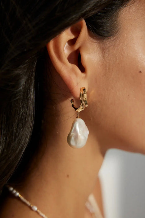 Close-up of Anaïs & Aimee's Gilded Flow Baroque Pearl Earrings, showcasing natural pearls with sculptural silver and gold tops, ideal for any occasion in London.