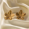 air of gold hibiscus flower earrings with detailed petals, displayed on a soft, ivory-colored fabric, highlighting their elegant and polished design.