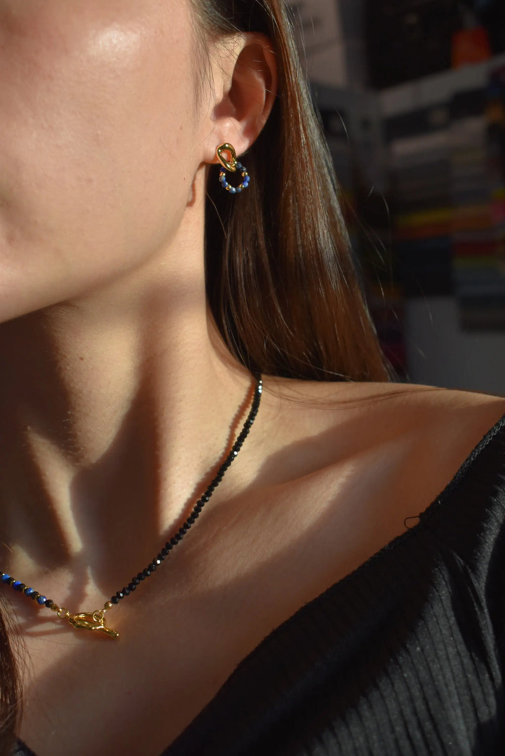 Model wearing the Lapis Lazuli Black Spinel Crystal Necklace and matching earrings, with the necklace resting elegantly on the collarbone and catching the light.