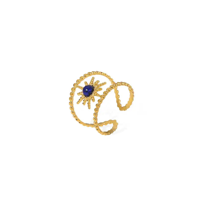  striking gold sunbeam bracelet with a central lapis lazuli stone. The bracelet features intricately designed rays emanating from the deep blue stone, creating a sun-like effect. The gold is textured along the spiral arms, enhancing the radiance of the design, set against a plain white background for contrast.