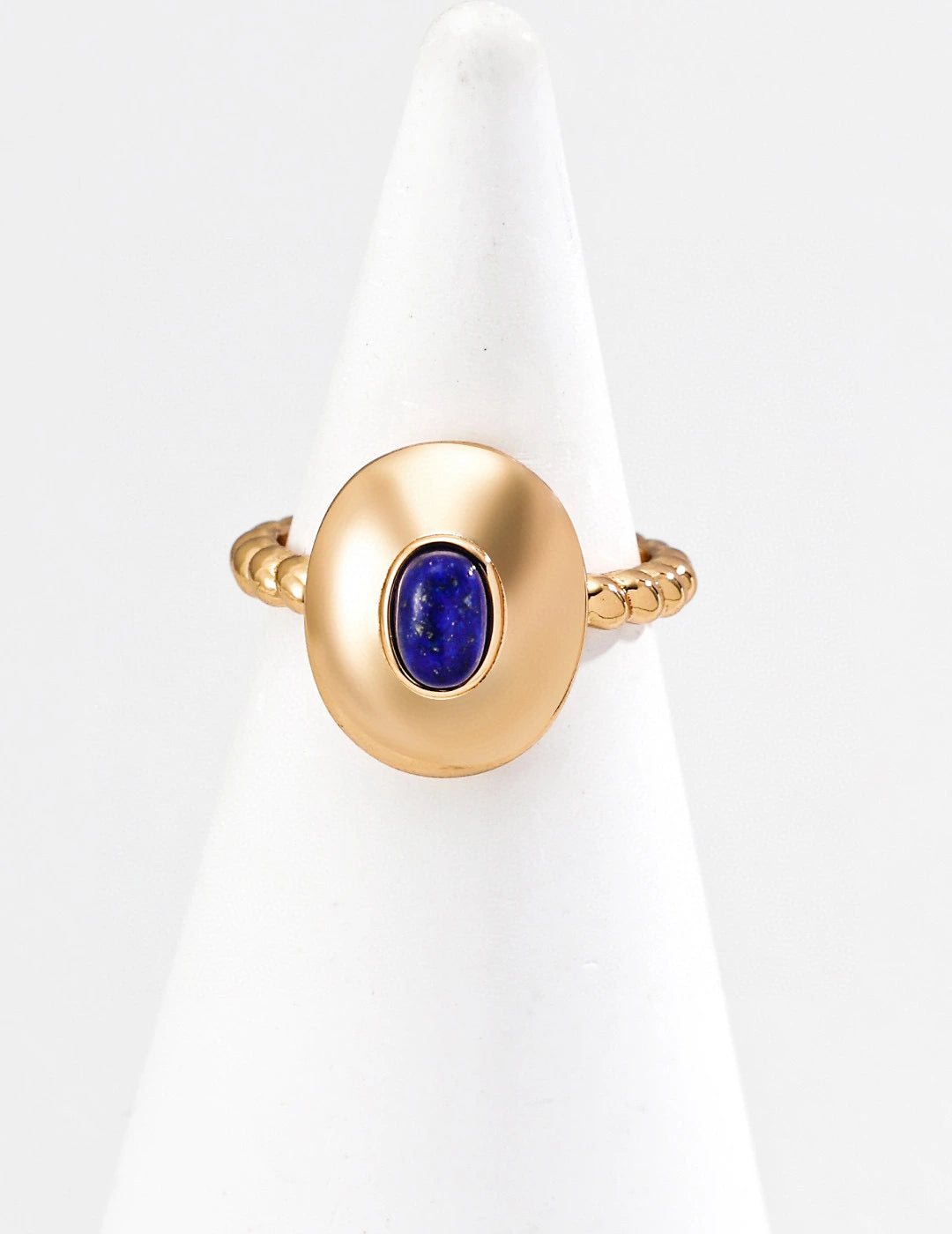 Gold ring with a blue gemstone on a white background