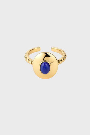 Gold ring with a blue gemstone on a light gray background