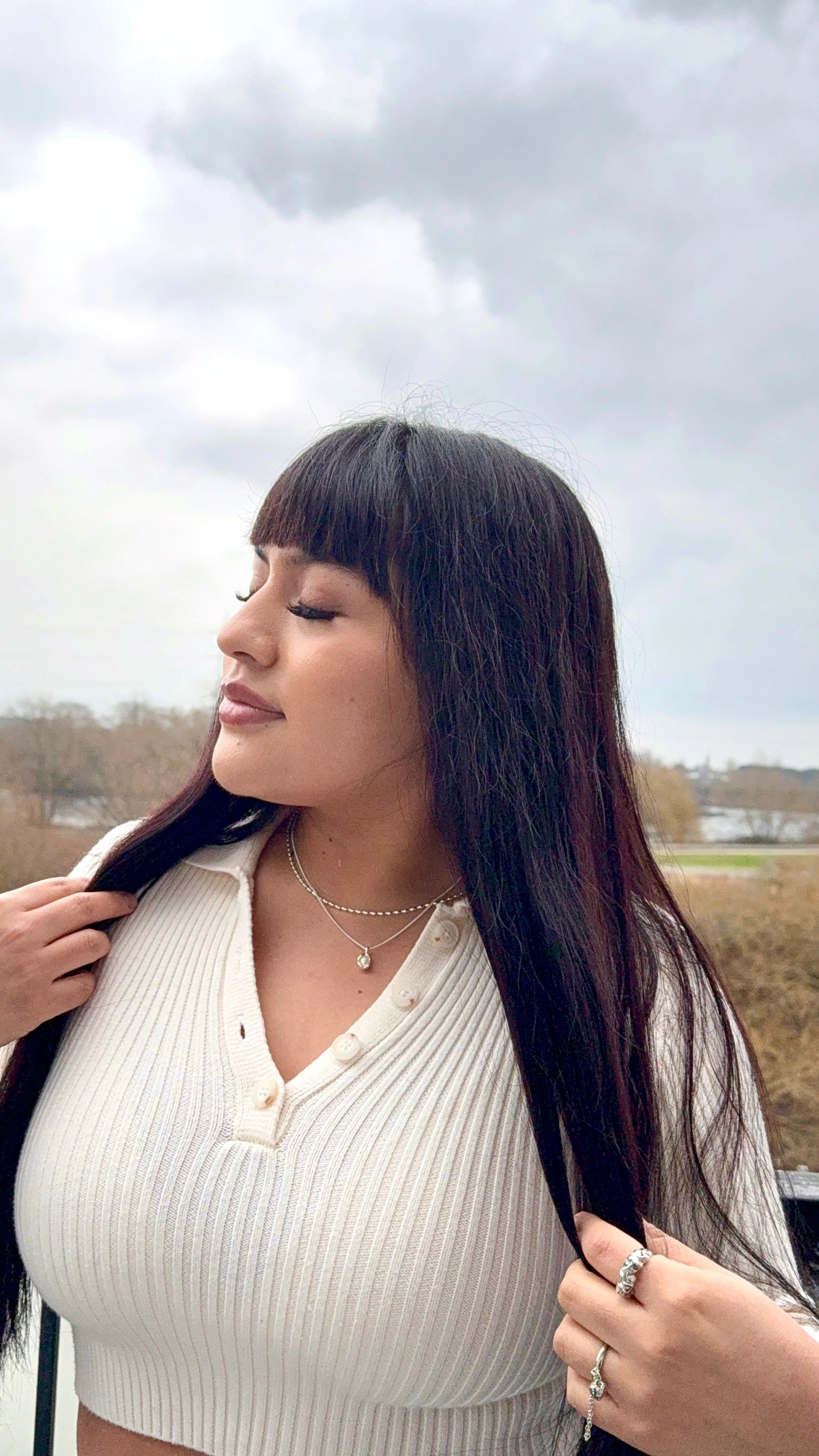 Woman wearing Anais&Aimee silver pearl pendant necklace and rings – UK jewellery brand