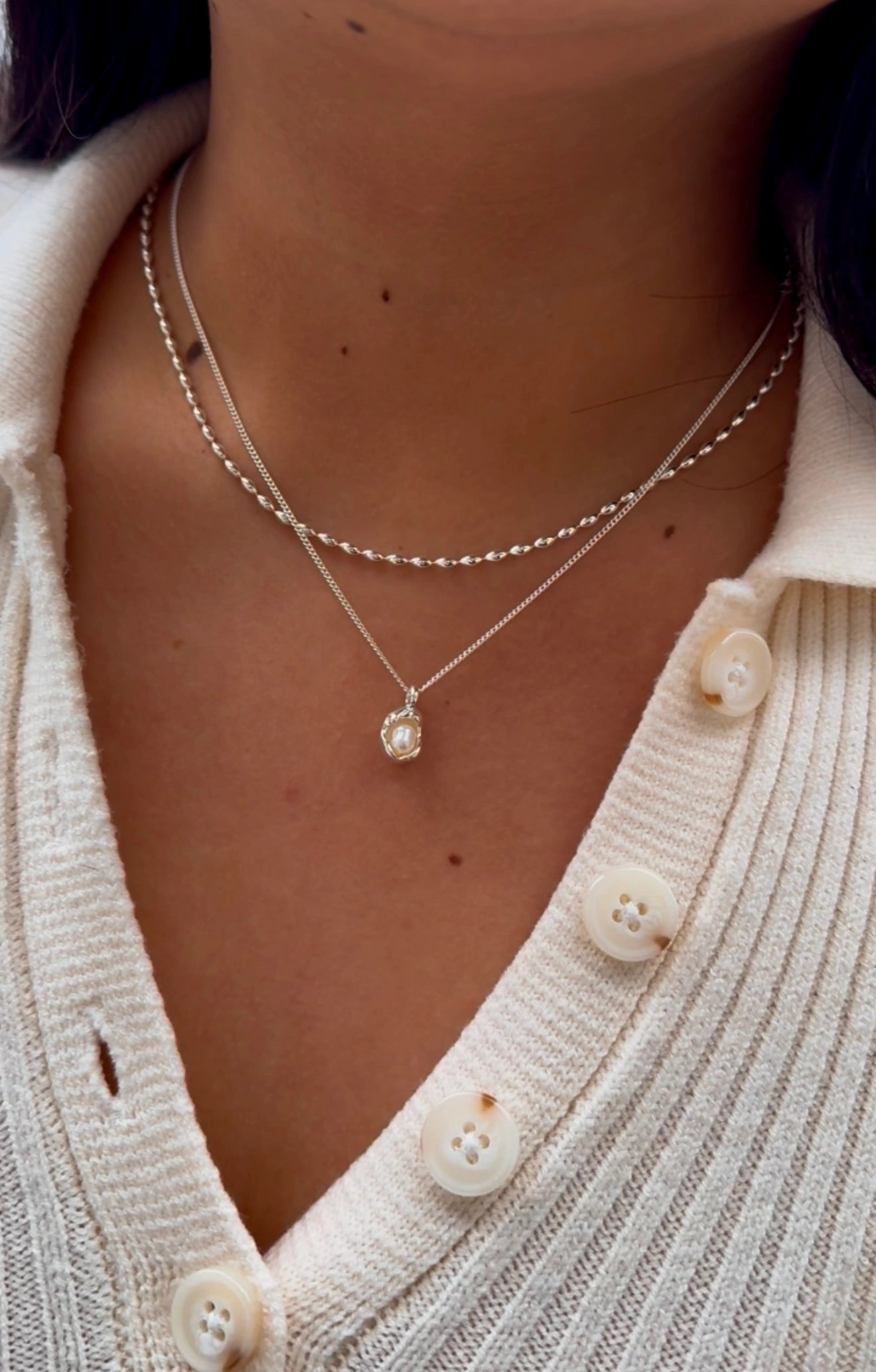 Close-up of Anais&Aimee silver pearl pendant necklace layered with chain – UK jewellery brand