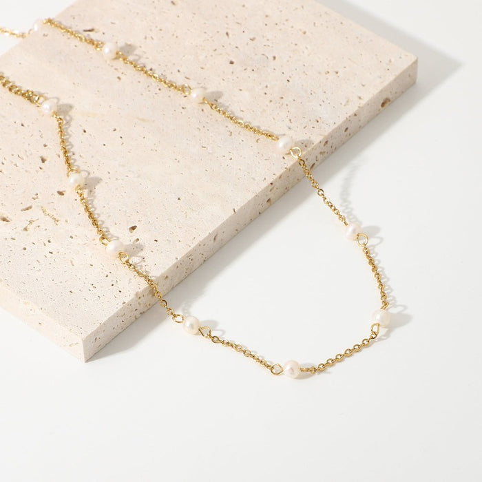 Anais & Aimee Aimee Gold Celestial Freshwater Pearl Chain Necklace displayed elegantly, featuring an adjustable gold vermeil chain adorned with glossy white freshwater pearls. Perfect for adding a touch of sophistication to any outfit.