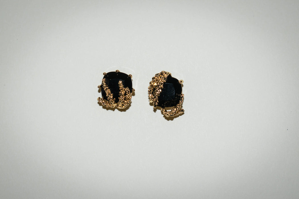 Close-up of Patchouli Flower Black Obsidian Stud Earrings by Anaïs & Aimée, front view with detailed gold embellishments surrounding the black gem.