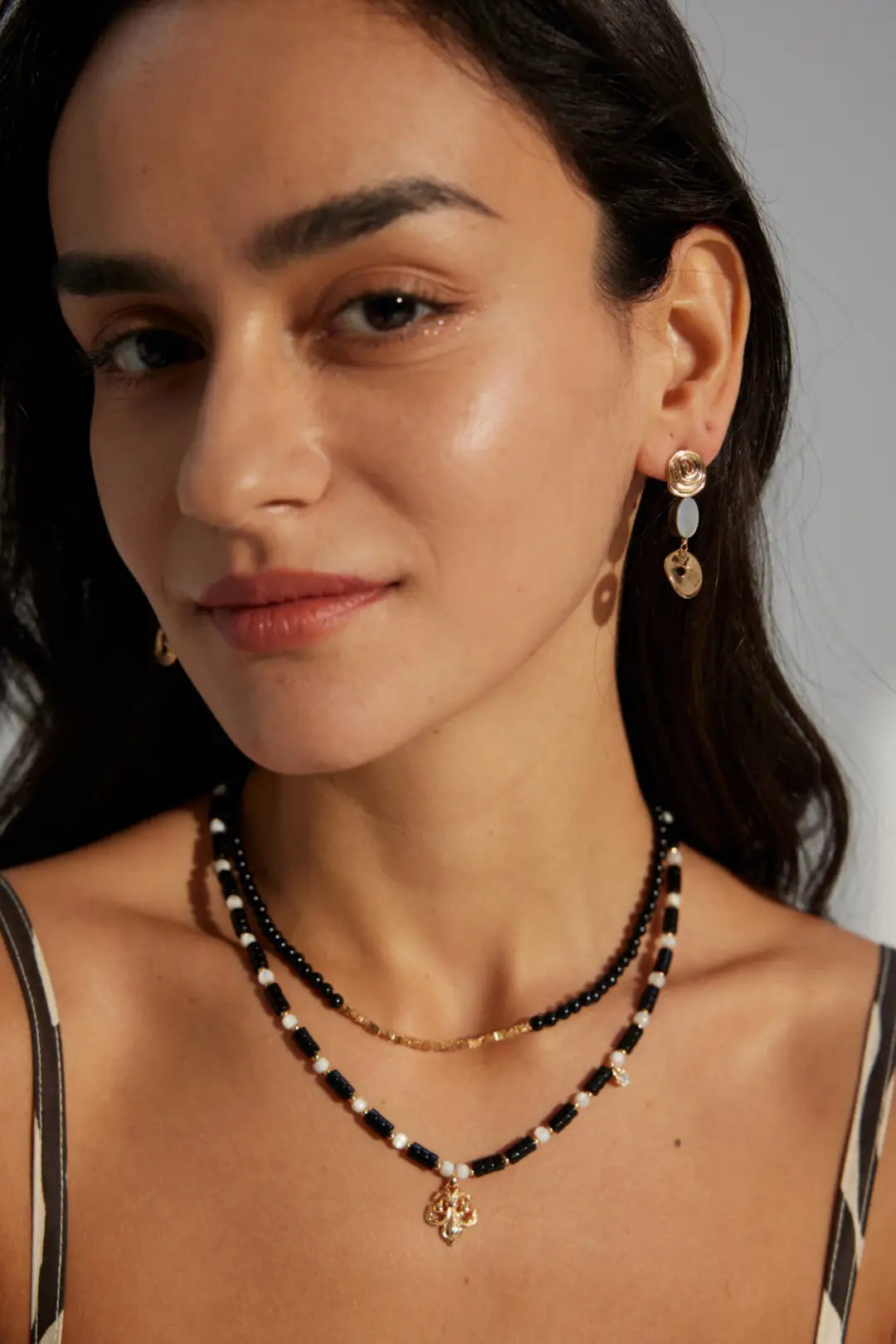 Anais & Aimee modern Royal Black Obsidian Pearl Necklace worn by a model, highlighting its refined elegance and timeless charm in a sophisticated look.

Image 4 (Royal Black Obsidian Pearl Necklace Close-Up)
ALT Text: Close-up view of the Anais & Aimee modern Royal Black Obsidian Pearl Necklace, featuring intricate Black Obsidian beads and delicate pearls for a luxurious appeal.

Image 5 (Royal Black Obsidian Pearl Necklace on Model)
ALT Text: Anais & Aimee modern Royal Black Obsidian Pearl Necklace gracefu