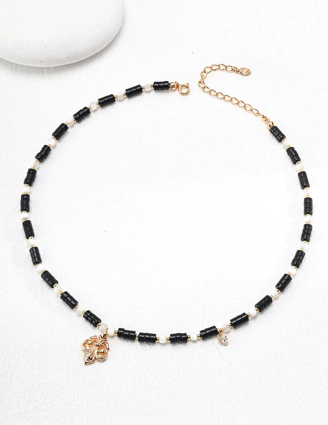 Anaïs & Aimee Black Obsidian Pearl Necklace on minimalistic surface, luxury design