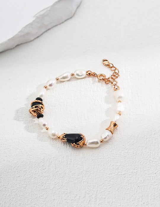 Close-up of the Serenity Black Obsidian Pearl Bracelet by Anaïs & Aimee in gold. Features radiant pearls, black obsidian gemstones, and gold detailing, perfect for adding a touch of elegance to any outfit in the UK.