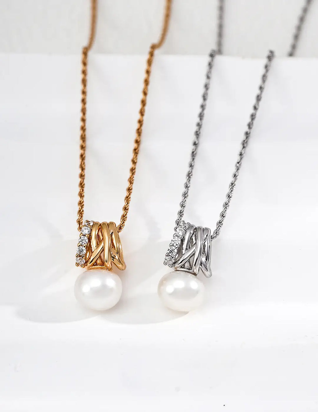 Two pearl necklaces on a white surface