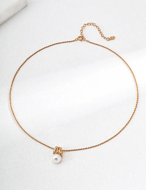 Gold necklace with a pearl pendant on a white background