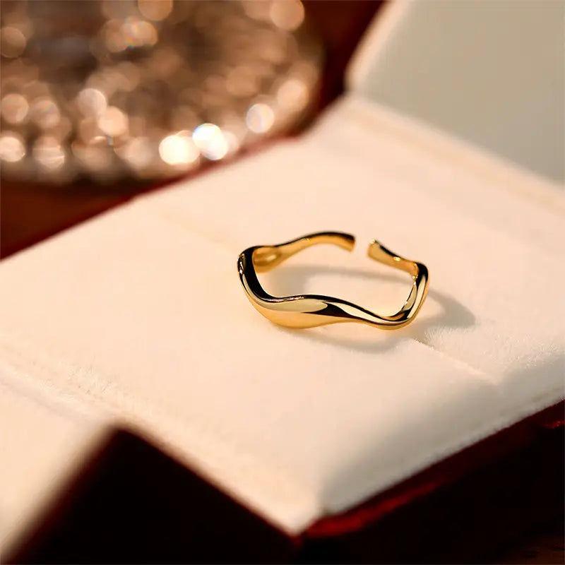 Elegant Wanstead Gold Cuff Ring - Adjustable with a wavy design, showcased on a white cushioned display box, reflecting a sophisticated and timeless appeal.