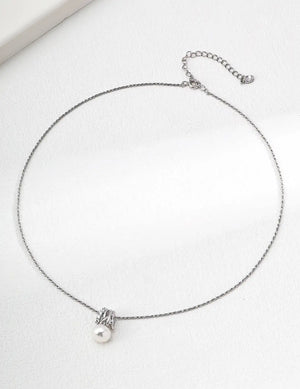 Silver necklace with a pearl pendant on a white background